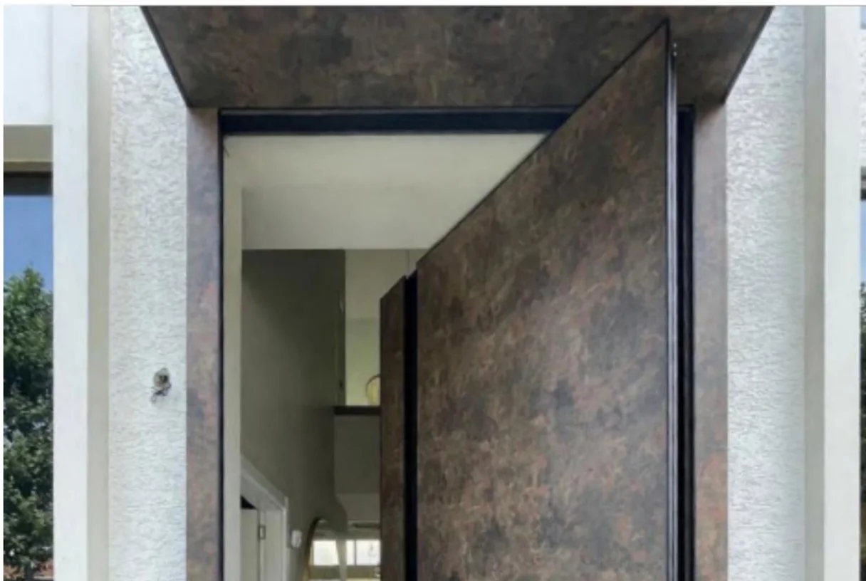 Dark aluminium offset-hinge entrance leaf with a brown cast-aluminium art panel open beside a doorway, design rendering
