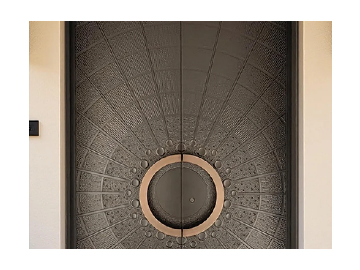 Front view of a dark aluminium double entrance leaf with a circular bronze pull and radial cast face