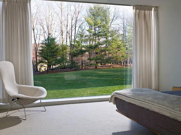 Wide six-chamber casement sashes looking out over a garden lawn